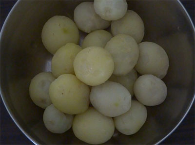 peeling potatoes for baby potato snacks or baby potato fry