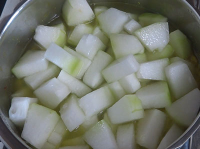 cooking kumbalakai huli or ash gourd sambar