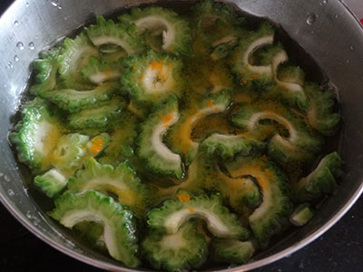 sliced bittergourd in salt water for hagalakai pakoda or bittergourd chips or karela fry