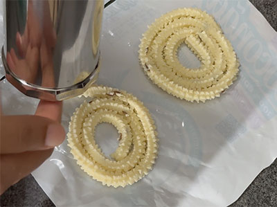 pressing the hesaru bele chakli or moong dal murukku recipe