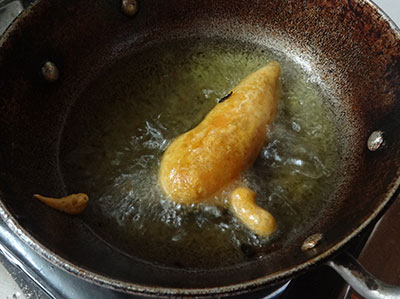 frying stuffed menasinakayi bajji or chilli bajji