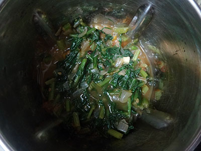 grinding the fried ingredients for palak soup