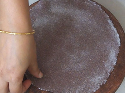 rolling the roti for ragi rotti or ragi chapathi