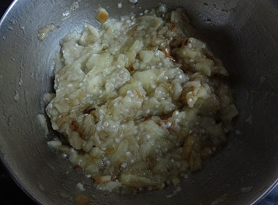 mashing charred brinjal for sutta badanekayi gojju