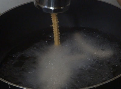 pressing tomato murukku or tomato chakli