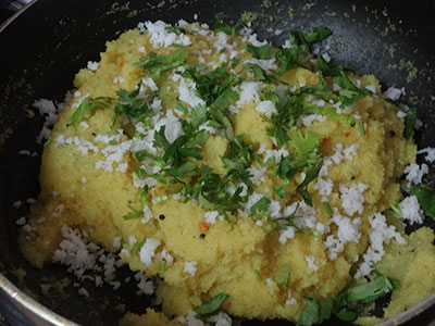 adding coconut and coriander leaves for upuma